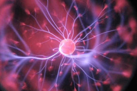  A plasma globe with pink and purple streams of electricity emanating from a central sphere to the glass surface